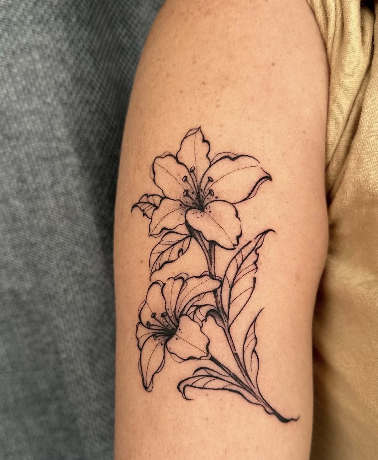 Tatuagem de lírios em traço fino no braço